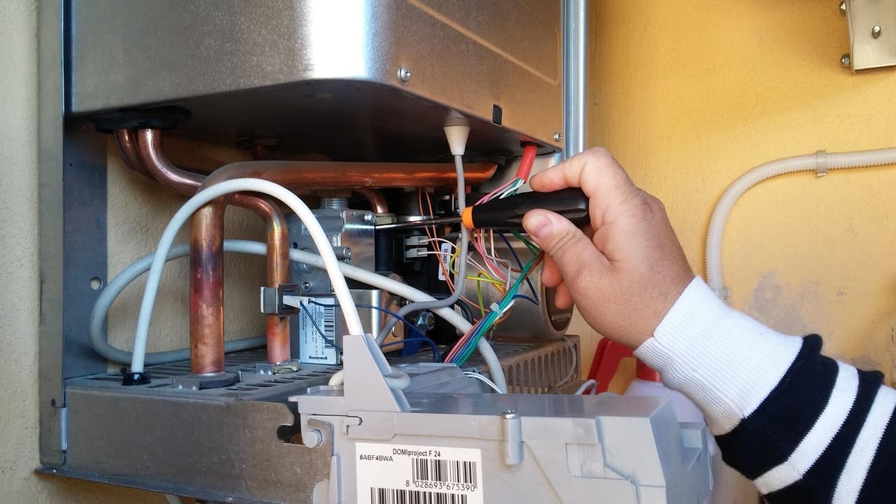 Engineer working inside an open gas boiler